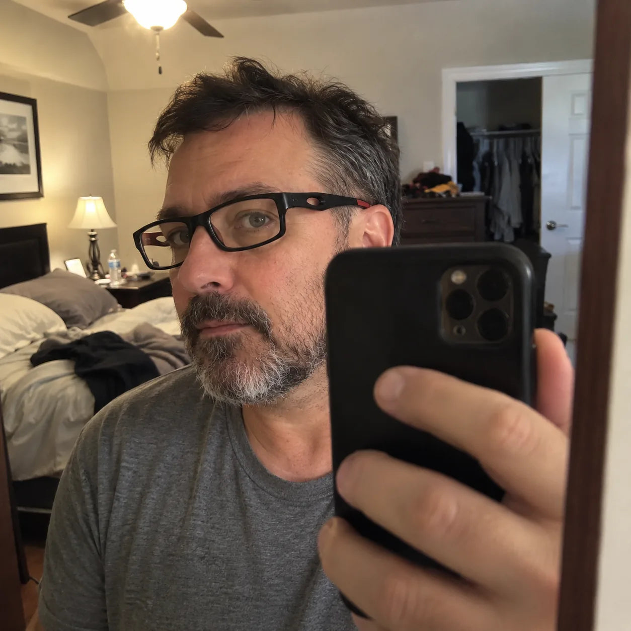 Customer wearing black and red glasses in a mirror selfie