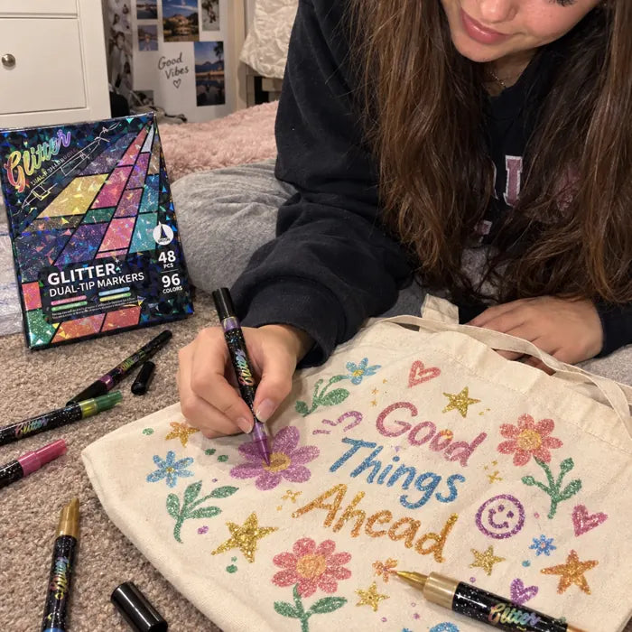 Teen decorating a canvas tote bag with glitter markers